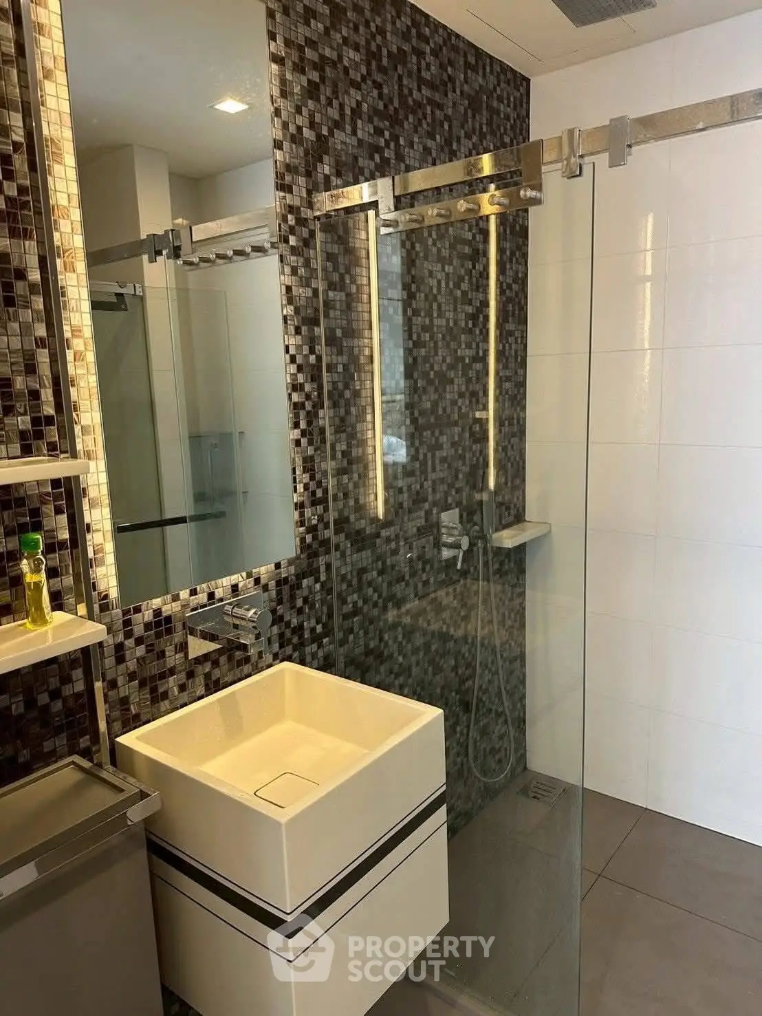 Modern bathroom with sleek glass shower and stylish mosaic tiles
