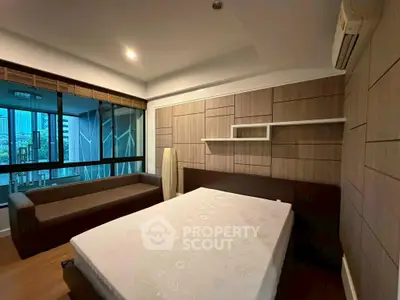 Modern bedroom with city view, featuring stylish wood paneling and large windows for natural light.