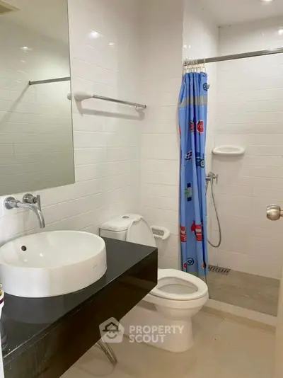 Modern bathroom with sleek fixtures and playful shower curtain