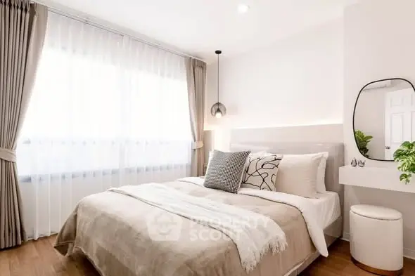 Elegant bedroom with modern decor, large window, and cozy bedding in a bright, inviting space.