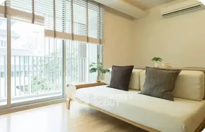 Bright living room with modern sofa and large windows overlooking balcony