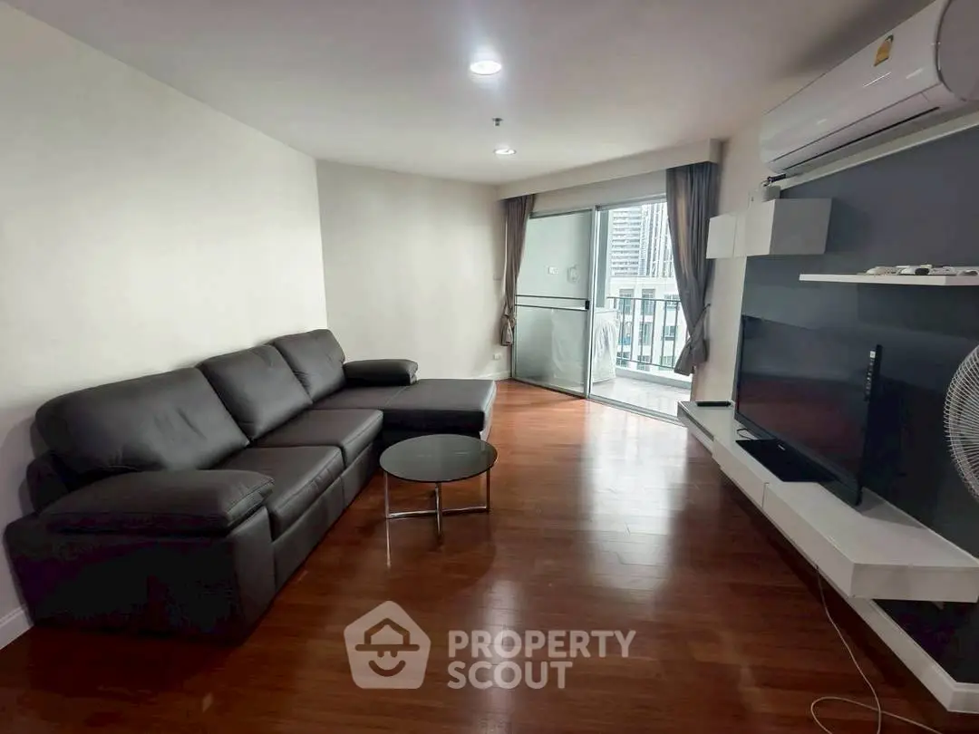 Modern living room with sleek furniture and city view balcony