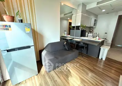 Modern apartment kitchen with sleek design and cozy seating area, featuring wooden flooring and stylish decor.
