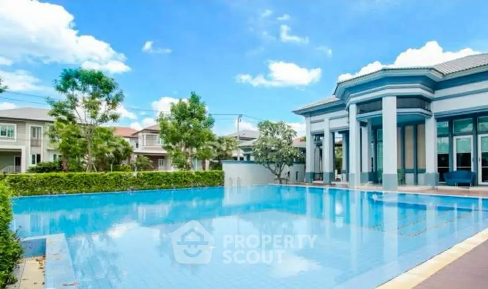 Luxurious residential pool area with modern architecture and lush greenery.