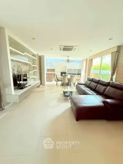 Spacious living room with modern leather sofa and elegant dining area