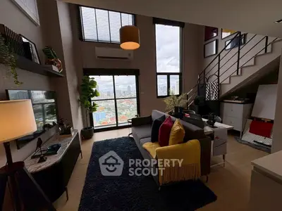 Modern living room with large windows and city view, featuring stylish decor and cozy seating area.