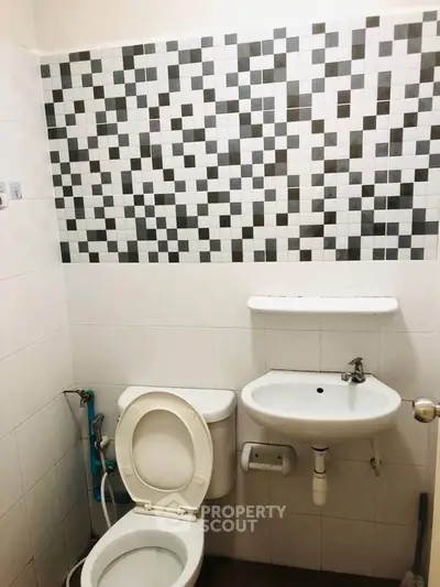 Compact bathroom with modern tile design and essential fixtures.