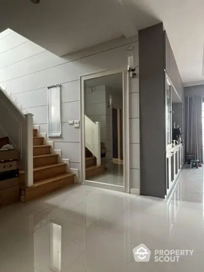 Modern interior with sleek staircase and glossy floor tiles