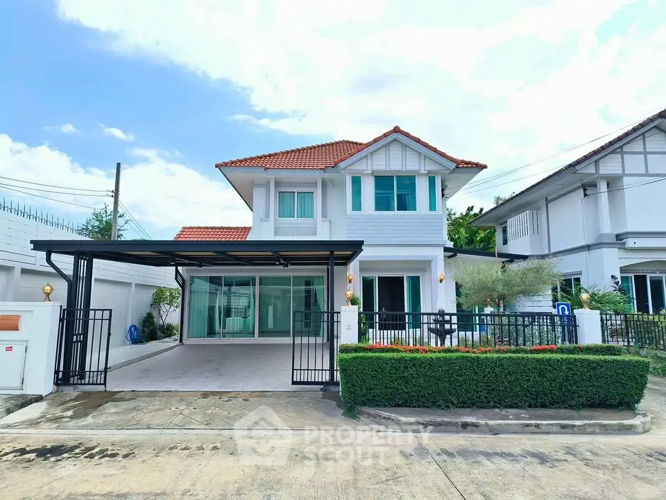 Charming two-story house with red roof and spacious driveway in a serene neighborhood.