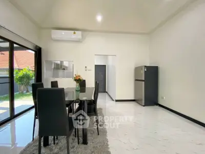 Spacious dining area with modern furniture and garden view, perfect for family gatherings.