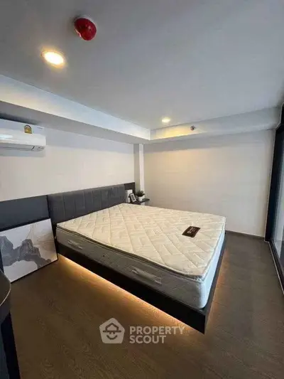 Modern bedroom with stylish lighting and air conditioning in a contemporary apartment.