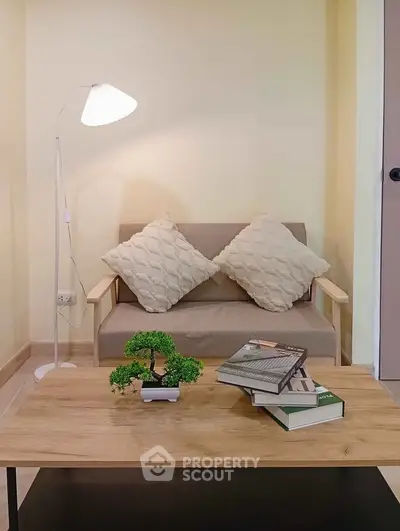 Cozy living room with stylish sofa, modern lamp, and elegant coffee table for a perfect relaxation space.