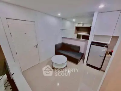 Modern compact living room with sleek furniture and integrated kitchen appliances.