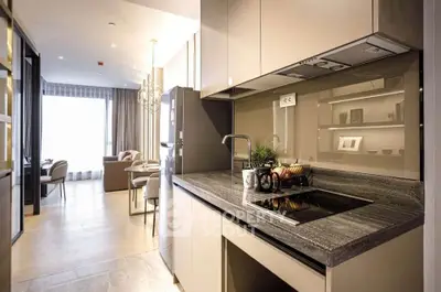 Modern kitchen with sleek design and open layout leading to a stylish living area.
