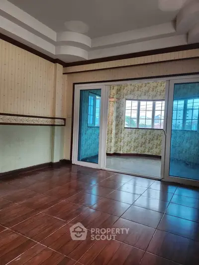 Spacious room with sliding glass doors and elegant wallpaper, perfect for versatile living space.