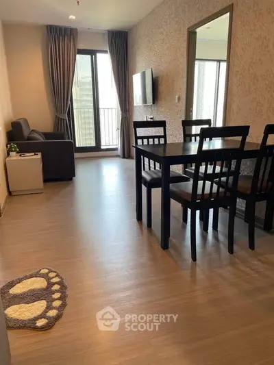 Modern living room with dining area and balcony access in a stylish apartment.