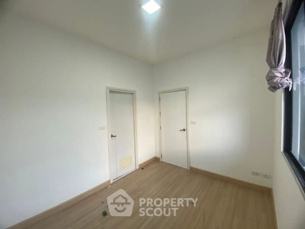 Minimalist empty room with wooden flooring and white walls