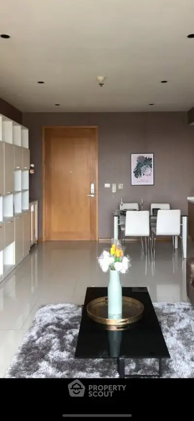 Modern living room with stylish decor and dining area, featuring sleek furniture and elegant design.