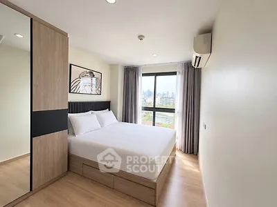 Modern bedroom with city view, featuring a large window, wooden flooring, and stylish decor.