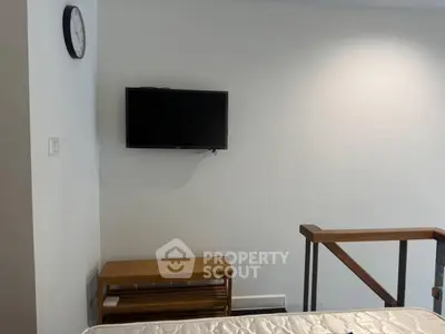 Modern minimalist interior with wall-mounted TV and wooden accents in a cozy living space.