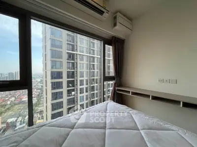 Modern bedroom with large windows offering stunning city views in a high-rise apartment.