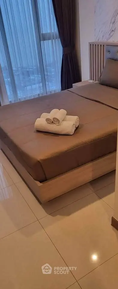 Luxurious bedroom with elegant decor and large windows offering natural light.