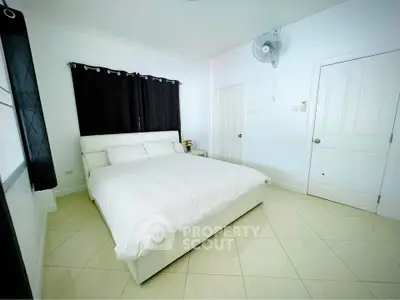 Bright and airy bedroom with modern white decor and large windows.