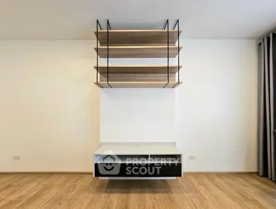 Modern minimalist living room with stylish wooden shelves and sleek flooring.