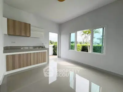 Spacious modern kitchen with open layout and large window offering garden view