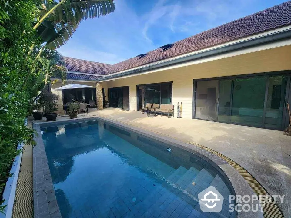 Luxurious villa with private pool and spacious patio under clear blue skies.