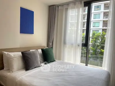 Modern bedroom with large window and stylish decor in urban apartment.