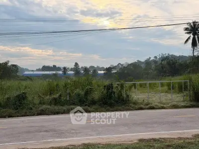 Scenic view of lush greenery and distant hills under a cloudy sky, perfect for tranquil living.