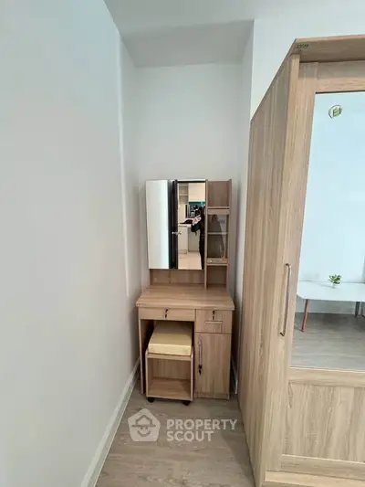 Compact bedroom corner with wooden wardrobe and vanity desk, ideal for small spaces.