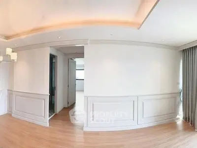 Spacious modern living room with elegant wall paneling and natural light