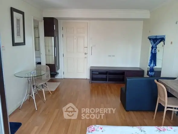 Spacious living room with wooden flooring and modern furniture in a cozy apartment.