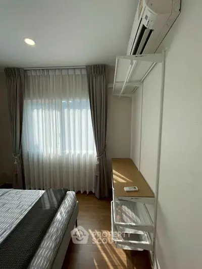 Modern bedroom with natural light, elegant curtains, and air conditioning for comfort.