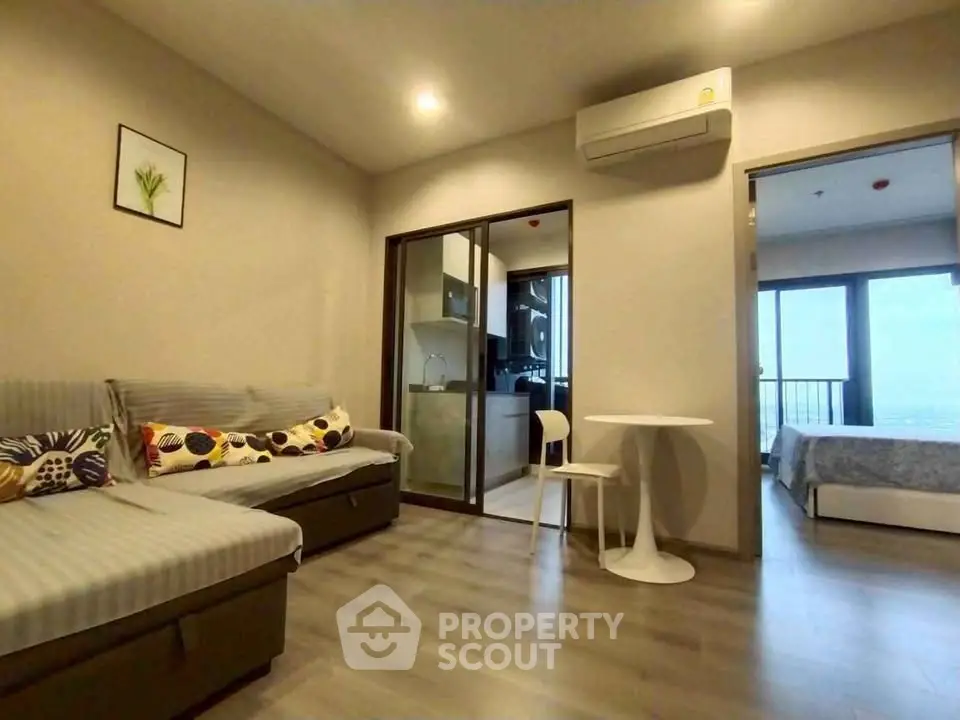 Modern apartment interior with open living room and kitchen, featuring stylish decor and natural light.