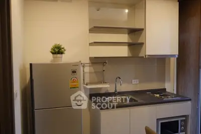 Modern compact kitchen with sleek cabinetry and stainless steel appliances.