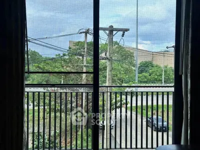 Scenic view from balcony overlooking lush greenery and urban landscape.