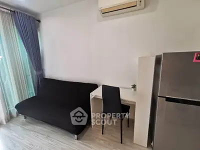 Modern living room with sleek furniture and air conditioning, featuring a cozy sofa and a compact workspace.