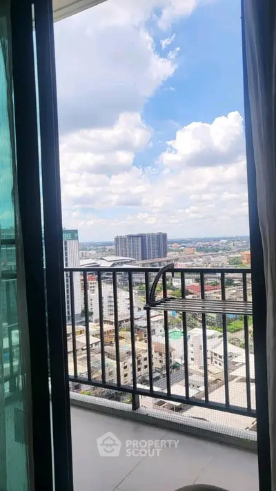 Stunning high-rise balcony view overlooking the city skyline with clear blue skies.