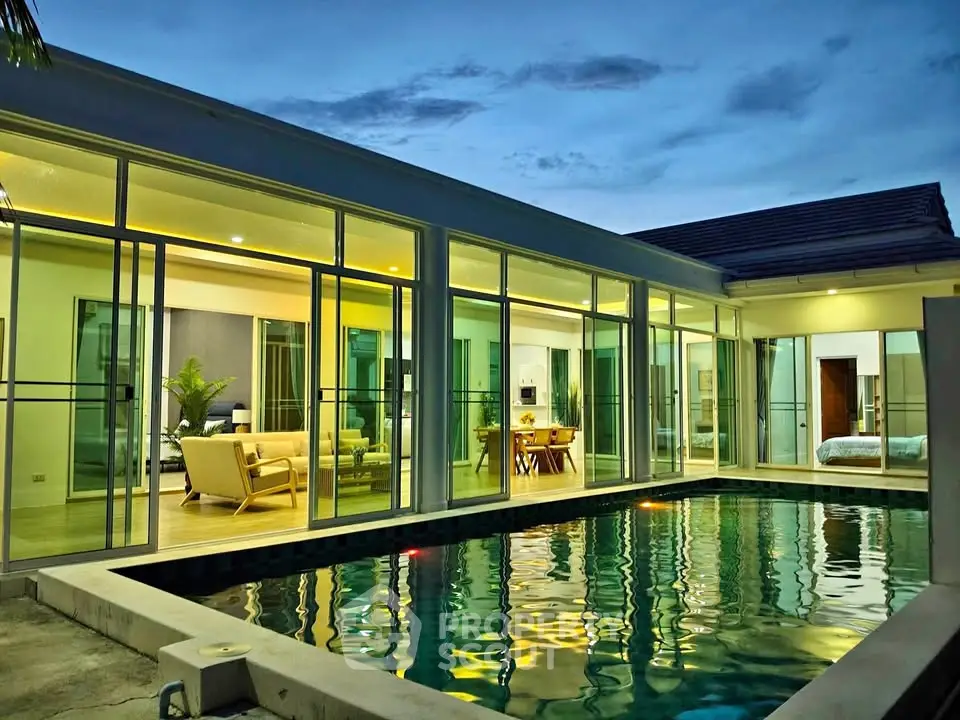 Luxurious modern home with stunning pool and glass walls at dusk