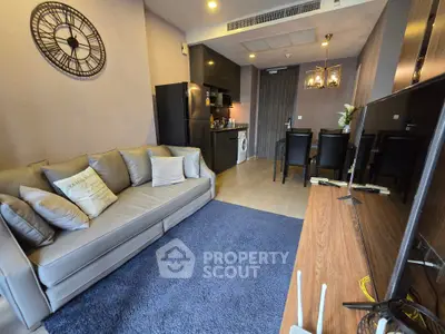 Modern living room with stylish decor, open kitchen, and cozy dining area in a contemporary apartment.