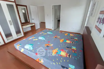 Spacious bedroom with colorful bedding and built-in wardrobe