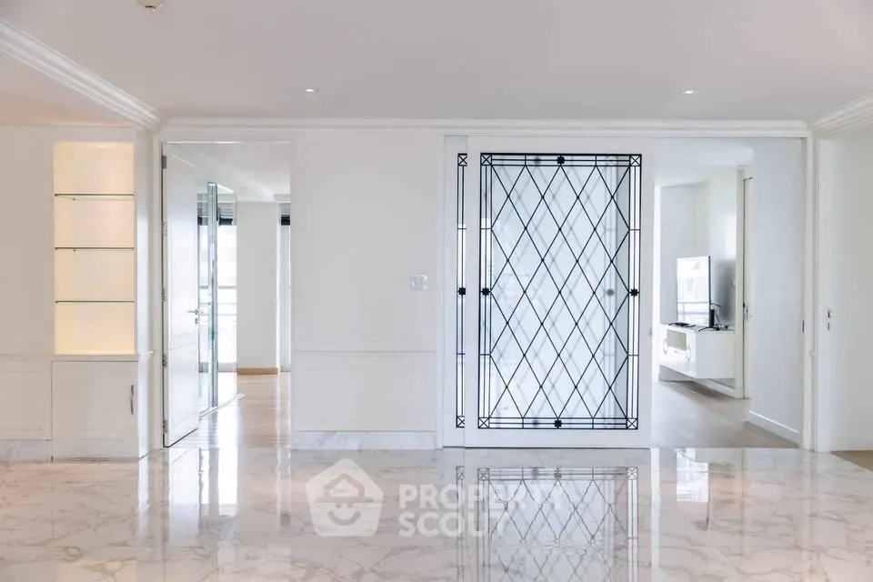 Luxurious marble-floored living space with elegant glass doors and built-in shelving, perfect for modern living.