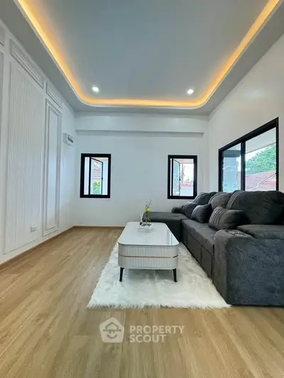 Spacious modern living room with elegant lighting and cozy seating area, perfect for relaxation.