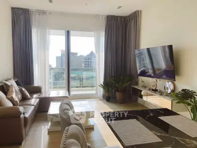 Modern living room with large TV and balcony view in luxury apartment.