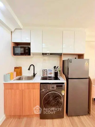 Modern kitchen with sleek appliances and stylish cabinetry in a compact layout.