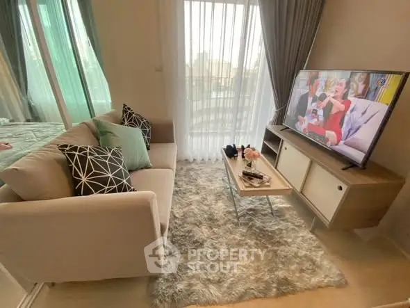 Cozy living room with modern decor and large TV, perfect for relaxation.