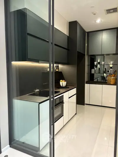 Modern kitchen with sleek cabinetry and built-in oven in a stylish apartment.